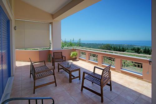 a balcony with chairs and a table and a view at Villa Myrto in Kyparissia