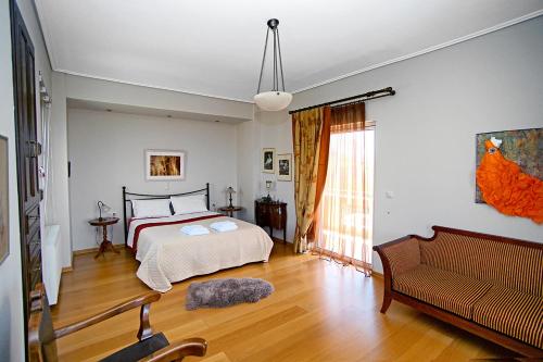 um quarto com uma cama e um sofá em Villa Myrto em Kyparissia