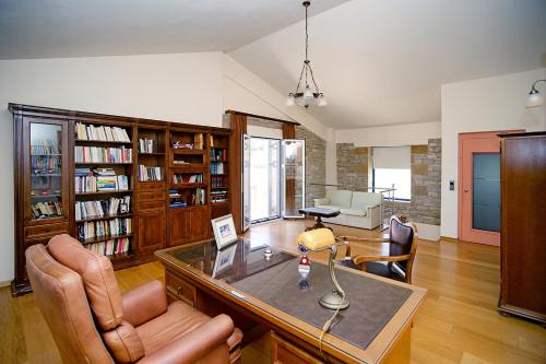 a living room with a desk with a lamp and chairs at Villa Myrto in Kyparissia