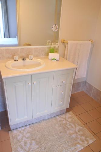 a bathroom with a white sink and a mirror at Koala Cove Holiday Apartments in Gold Coast