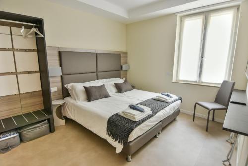 a bedroom with a large bed and a chair at 3 Amici Suites in Verona