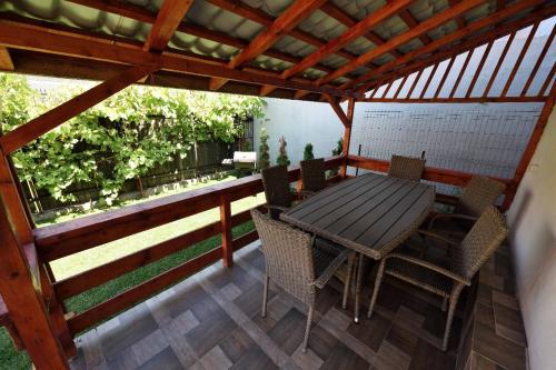 eine Terrasse mit einem Holztisch und Stühlen darauf in der Unterkunft Casa Optim in Călimăneşti