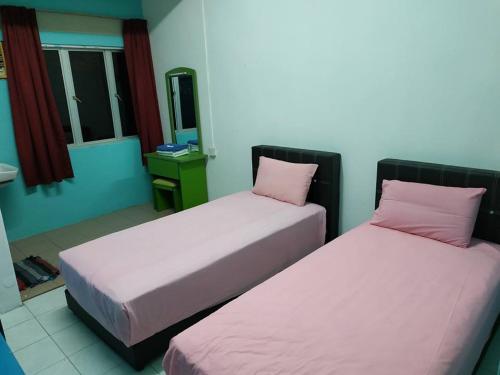 two beds in a room with pink pillows at Formosa Hotel Apartment in Melaka