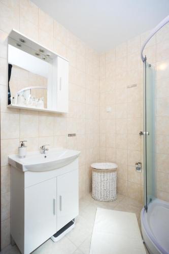 a white bathroom with a sink and a shower at Apartment Zlatko in Rovinj