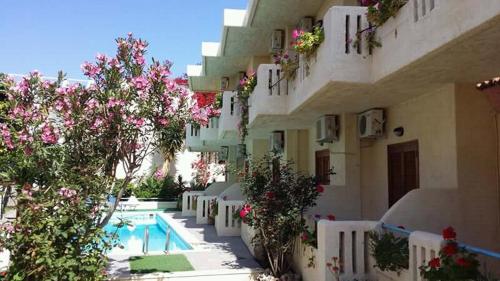 een gebouw met een zwembad en bomen en bloemen bij Hotel Elida in Platanes