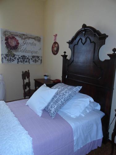 a bedroom with a bed with a large wooden headboard at Albergo & Ristorante Selvatico in Rivanazzano
