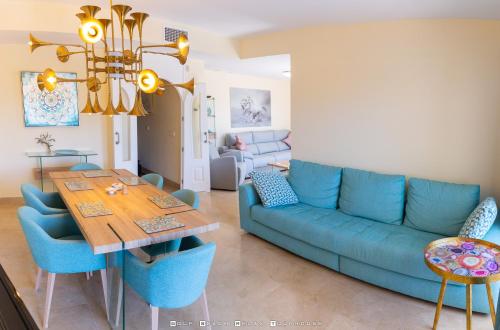 - un salon avec un canapé bleu et une table dans l'établissement Golf Beach and Relax Townhouse, à Alcaidesa
