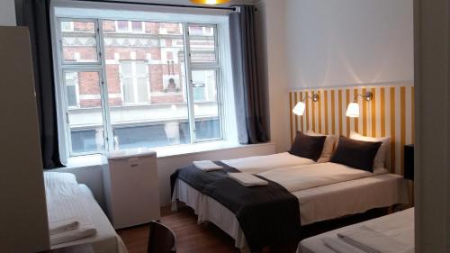 
a hotel room with two beds and a window at Hotel Løven in Copenhagen
