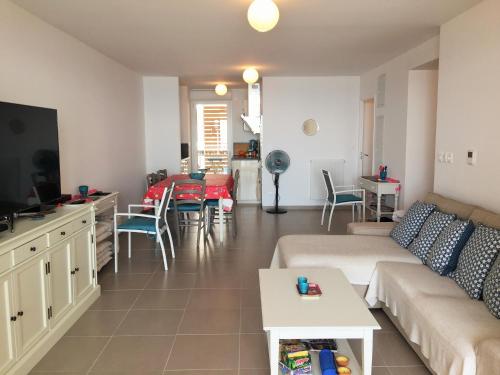 a living room with a couch and a table at Meuble de tourisme classé, climatisation, pieds dans l'eau in Palavas-les-Flots