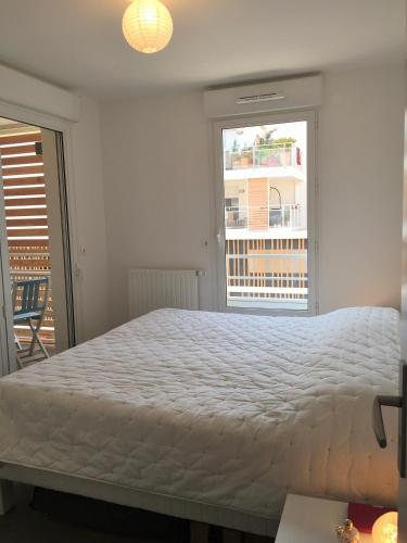 une chambre avec un grand lit et une grande fenêtre dans l'établissement Meuble de tourisme classé, climatisation, pieds dans l'eau, à Palavas-les-Flots