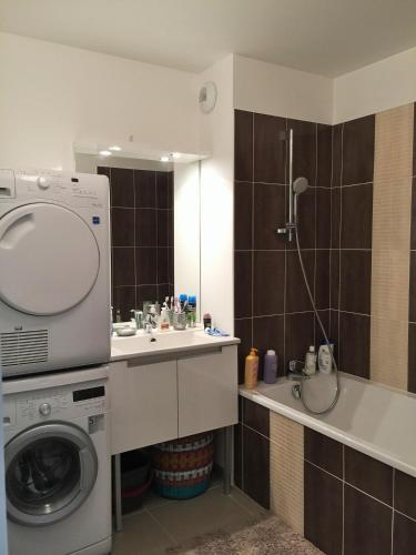 une salle de bain avec une machine à laver et un lavabo dans l'établissement Meuble de tourisme classé, climatisation, pieds dans l'eau, à Palavas-les-Flots