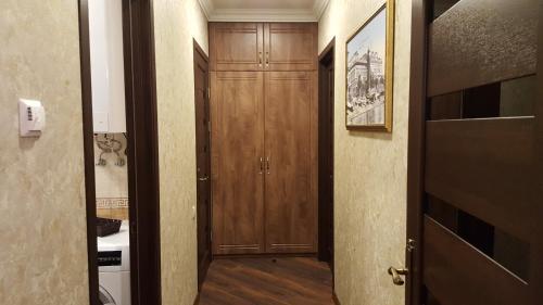 a hallway with wooden cabinets and a door to a room at Mimino Apartment Deluxe First Line (C I) in Batumi
