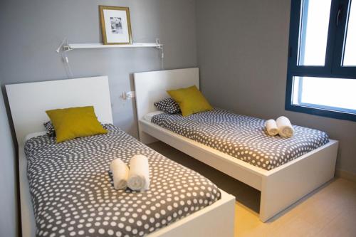 コスタ・テギセにあるLos Charcosの小さな部屋のツインベッド2台(黄色い枕付)