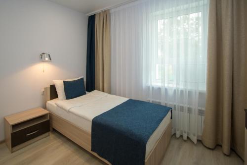 a small bedroom with a bed and a window at Hotel VERA in Yekaterinburg