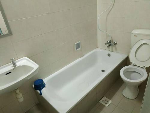 a bathroom with a tub and a toilet and a sink at Formosa Hotel in Malacca