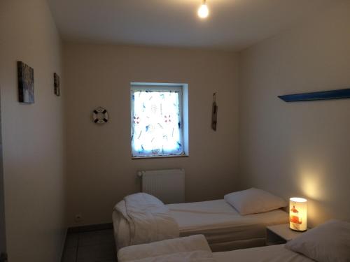 een kamer met twee bedden en een raam bij Ar baradoz in Guiler-sur-Goyen