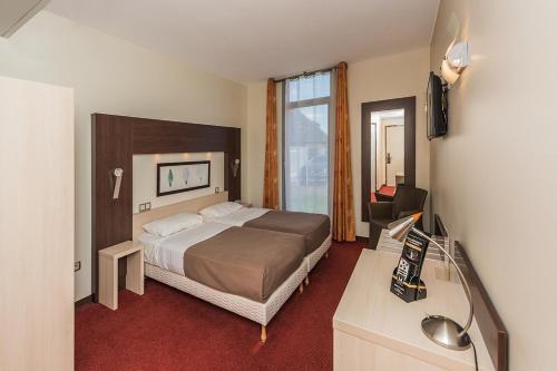 Postel nebo postele na pokoji v ubytování Hostellerie Saint Vincent Beauvais Aeroport