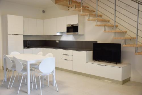 - une cuisine avec une table blanche et des chaises blanches dans l'établissement Green Marine Family Villas, à Lido di Jesolo