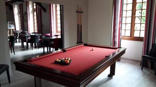 a red pool table in a room with ahibition at Logis Hostellerie Du Grand Duc hôtel restaurant in Gincla