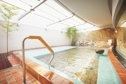 a swimming pool with a pool at Takanokono Hotel in Matsuyama