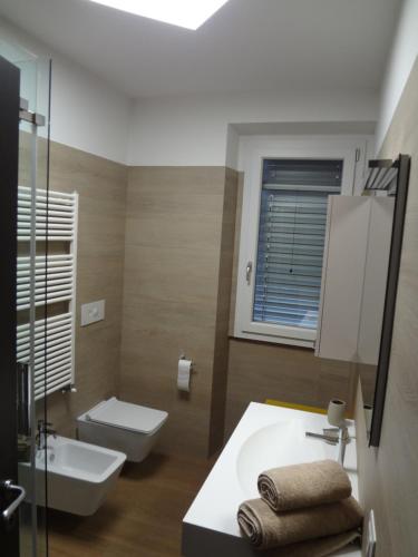 Un baño con un lavabo blanco y un inodoro. en La vita è bella, en Castiglion Fiorentino