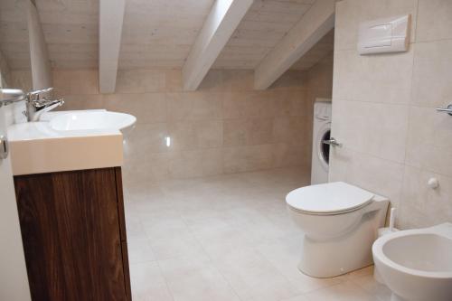 une salle de bain avec un lavabo et des toilettes dans l'établissement Green Marine Family Villas, à Lido di Jesolo