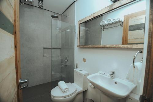 a bathroom with a shower and a toilet and a sink at The Bricks Hotel in Dumaguete