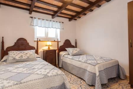 a bedroom with two beds and a window at Casa rural-Granja (La casa de la abuela Juana) in Conil de la Frontera