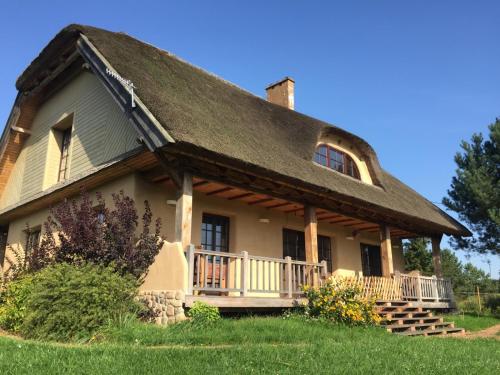 ein altes Haus mit einem Strohdach in der Unterkunft Dom na Krańcu Świata in Łapicze