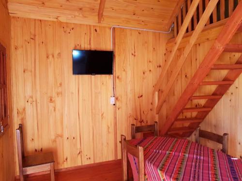 a bedroom with a bed in a wooden cabin at Los Teros in Goya