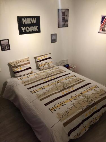 a bedroom with a bed with a new york sign on the wall at Au Nid de Tillé in Tillé