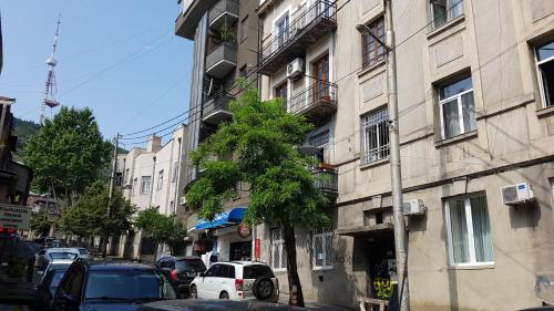 a city street with cars parked in front of a building at Sweet Rooms Inn in Tbilisi City