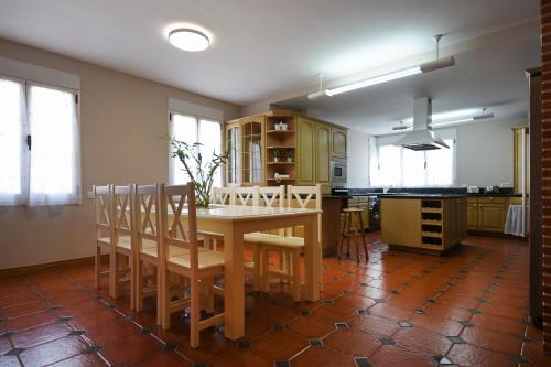 a kitchen with a wooden table and chairs in it at Los Olivos in Nava de la Asunción