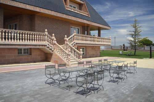 a patio with a table and chairs in front of a building at Los Olivos in Nava de la Asunción