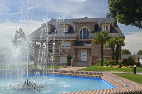 a house with a fountain in front of a house at Los Olivos in Nava de la Asunción