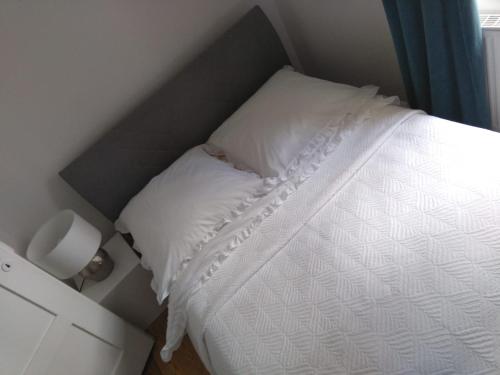 a bedroom with a bed with white sheets and a window at Ferienwohnung West in Stuttgart