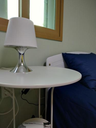 a white table with a lamp next to a bed at Seoul Forest Stay in Seoul