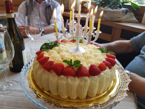 a cake with strawberries and candles on a table at Hotel Pedretti in Branzi