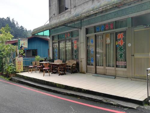 a building with tables and chairs on the side of the street at Qun Feng Hotel in Fenchihu