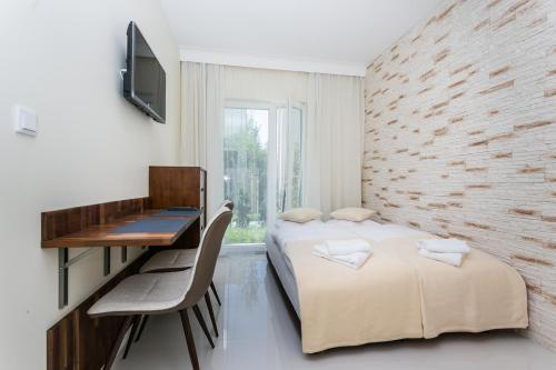 a bedroom with two beds and a desk and a window at Apartamenty Dom Saski 10 minut od Centrum Warszawy in Warsaw