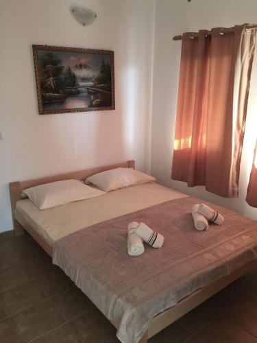 a bedroom with a bed with two slippers on it at Apartmani Labovic in Budva