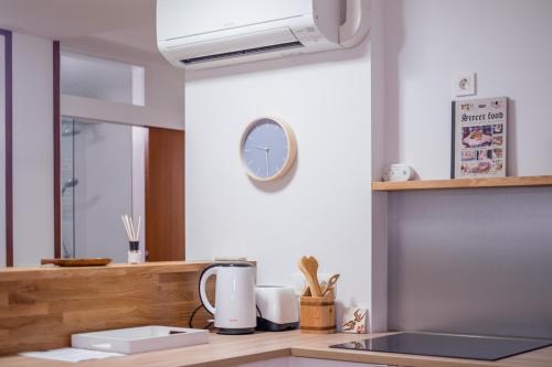 a kitchen with a counter with a clock on the wall at HOMe apartments & Yoga studio in Bled-Rečica