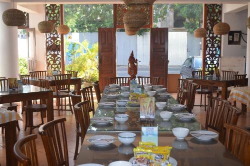 une longue table avec des bols et des assiettes dessus dans un restaurant dans l'établissement Hotel Paradiso, à Hikkaduwa