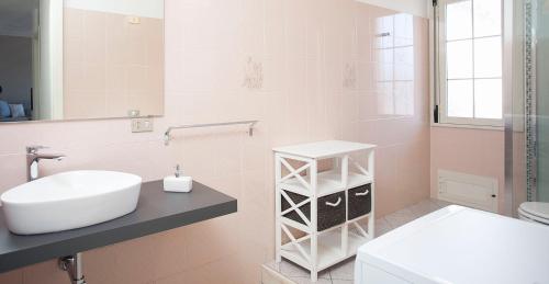 a bathroom with a sink and a toilet and a mirror at La Casa di Mattia in Pula