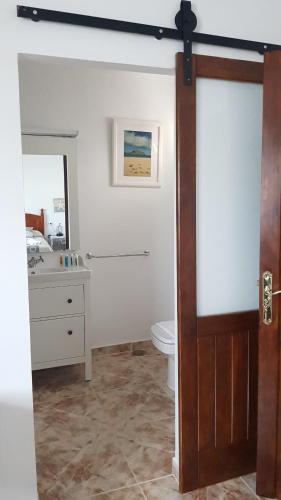 Un baño con inodoro, lavabo y espejo. en Casa Makuki, en Playa Honda