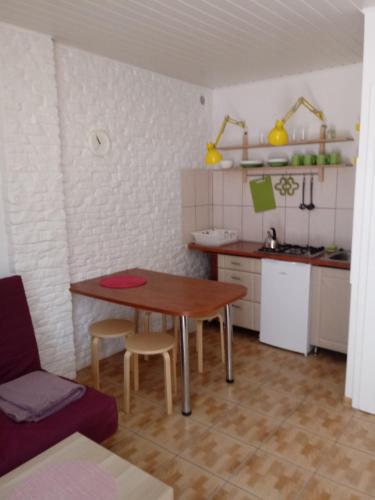 uma cozinha com mesa e cadeiras num quarto em Domki Elżbieta em Swarzewo
