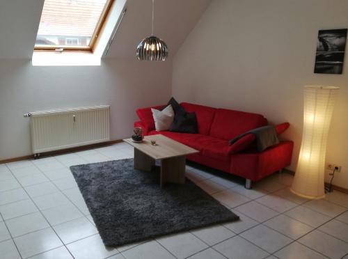 a living room with a red couch and a coffee table at Fa Haack in Neuried