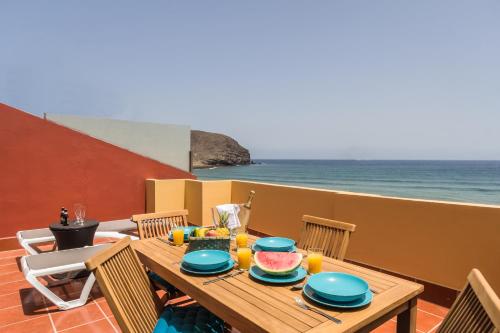 a wooden table with food on top of a balcony at Ocean View Penthouse II in Gran Tarajal