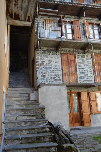a stairway leading up to a building with wooden doors at Appartamento Curnet in Balme