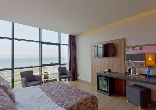 a hotel room with a bed and a view of the ocean at Euphoria Batumi Convention & Casino Hotel in Batumi